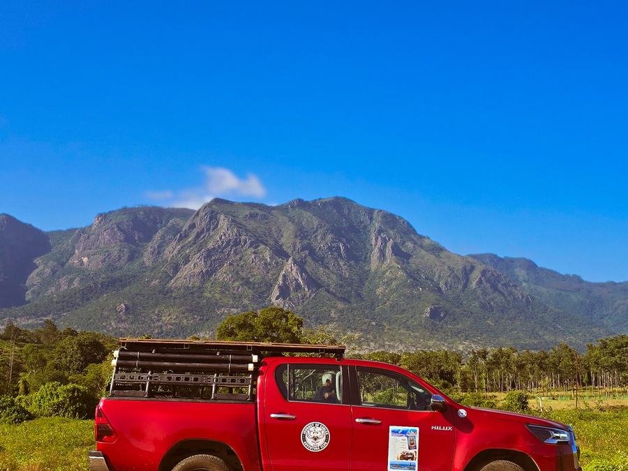 Red safari jeep below the Nilgiri mountains