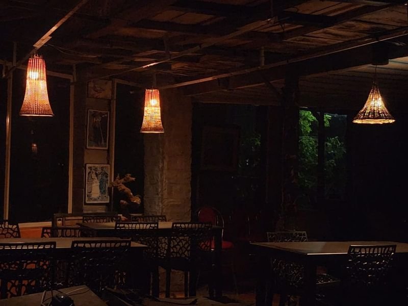 Dining area lit by woven pendant lamps in the evening