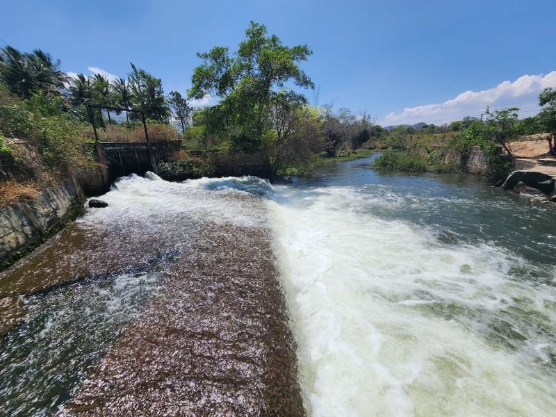 River spilling over a weir under a blue sky