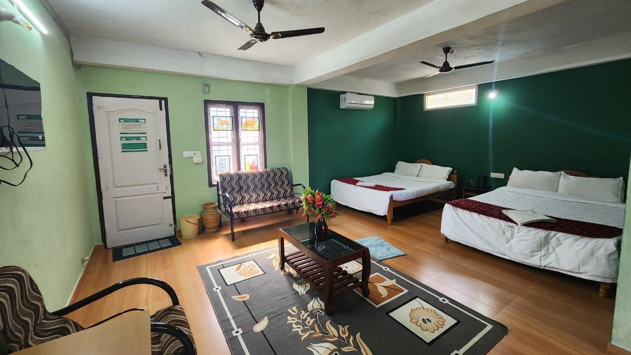 Family room with two double beds, a sofa, coffee table and ceiling fans